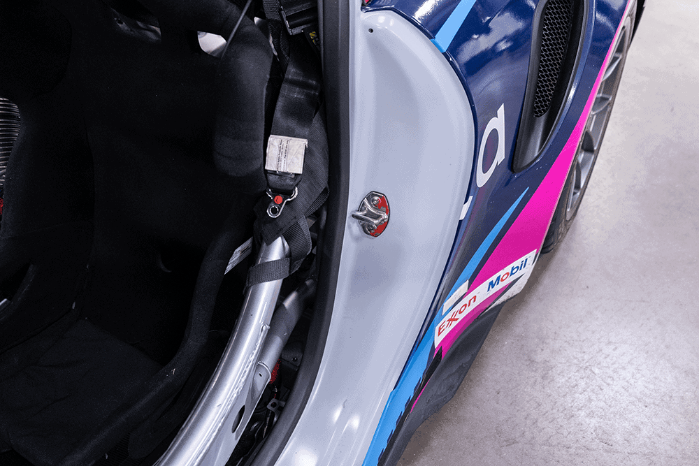Close-up of Porsche 911 Cup Car 992 interior with racing seat and safety harness.