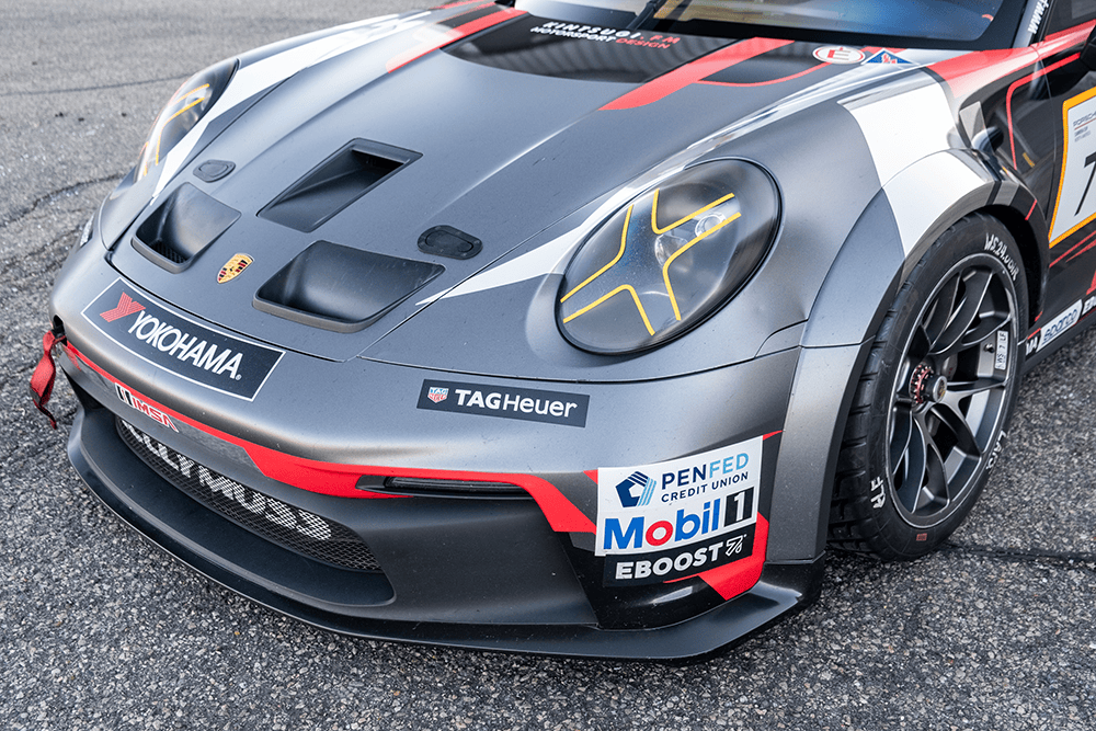 Close-up of Porsche 911 GT3 Cup 992 race car front with sponsor decals.