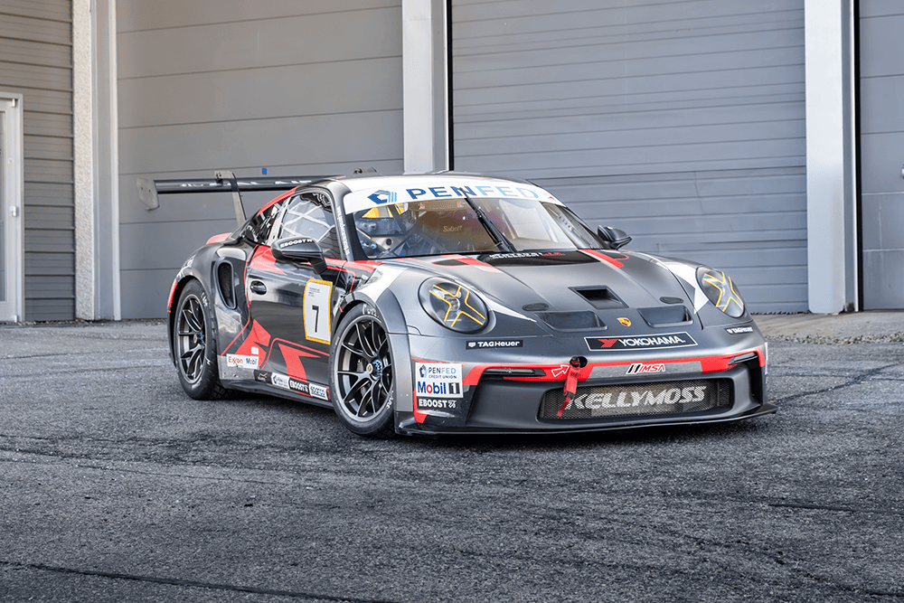 Kellymoss Porsche 911 GT3 Cup race car in a garage setting.
