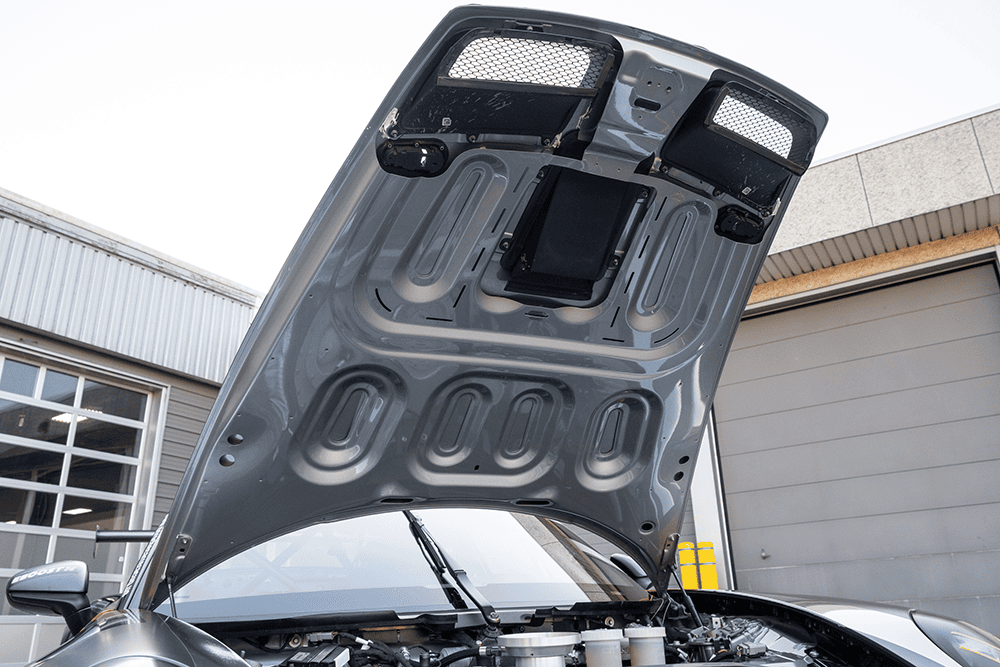 Close-up of the open engine hood of a Porsche 911 GT3 Cup 992.