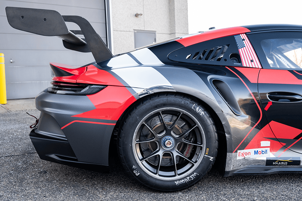 Close-up of a Kellymoss Porsche 911 GT3 Cup 992 race car rear side.