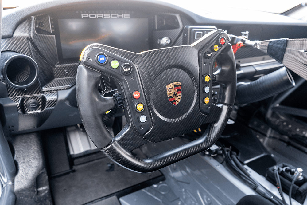 Racing steering wheel inside a Porsche 911 GT3 Cup 992 race car.