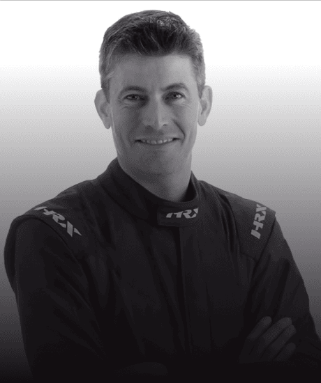 Portrait of a race car driver in a black racing suit at GT World Challenge America.