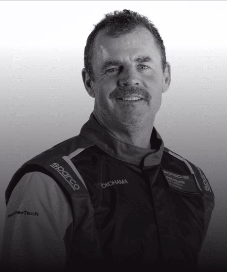 Race car driver in racing suit at GT World Challenge America event.