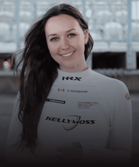 Kellymoss racing driver E. Hoffmann smiling in racing suit at Pirelli GT4 America event.