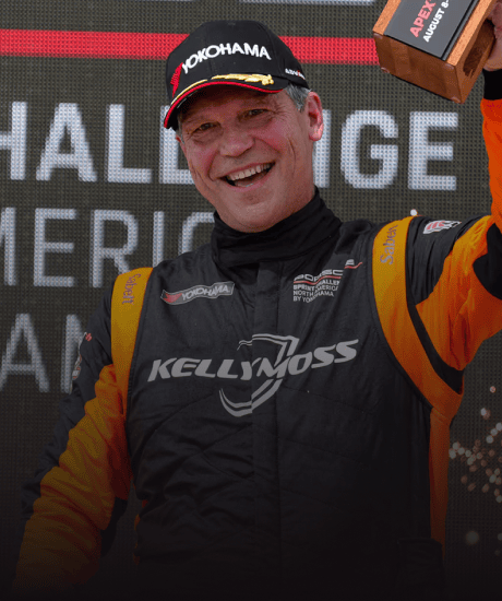 Kellymoss racing driver celebrating on the podium at Porsche Club of America event.