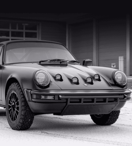 Classic Porsche 911 with off-road tires in black and white.