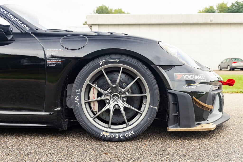 Close-up of black 2025 GT4 Clubsport RS race car front wheel and aerodynamic body.