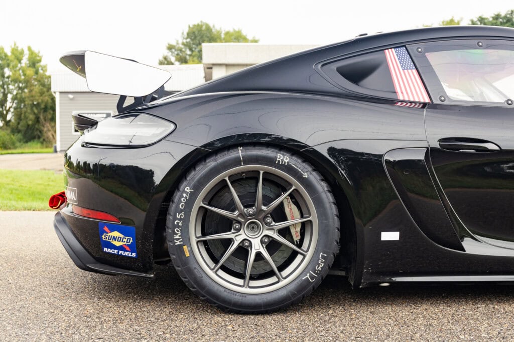 Black race car with Sunoco and American flag decals, racing tires, and aerodynamic features.