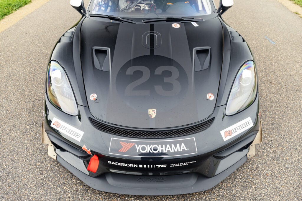 Black Porsche 911 GT4 Clubsport RS race car with number 23 and sponsor logos.