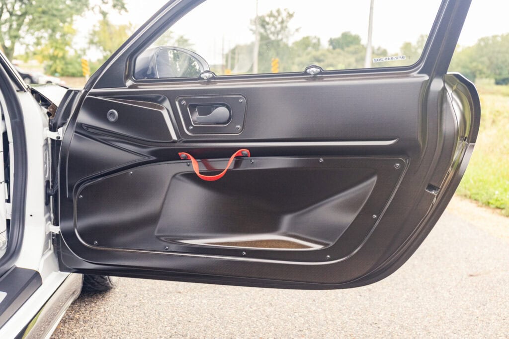 Close-up of a car door interior showing safety handle and storage compartment.
