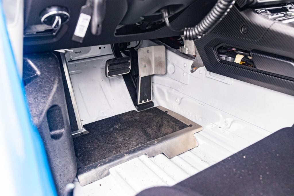 Interior of a 2025 GT4 Clubsport RS showing racing pedals and floor.