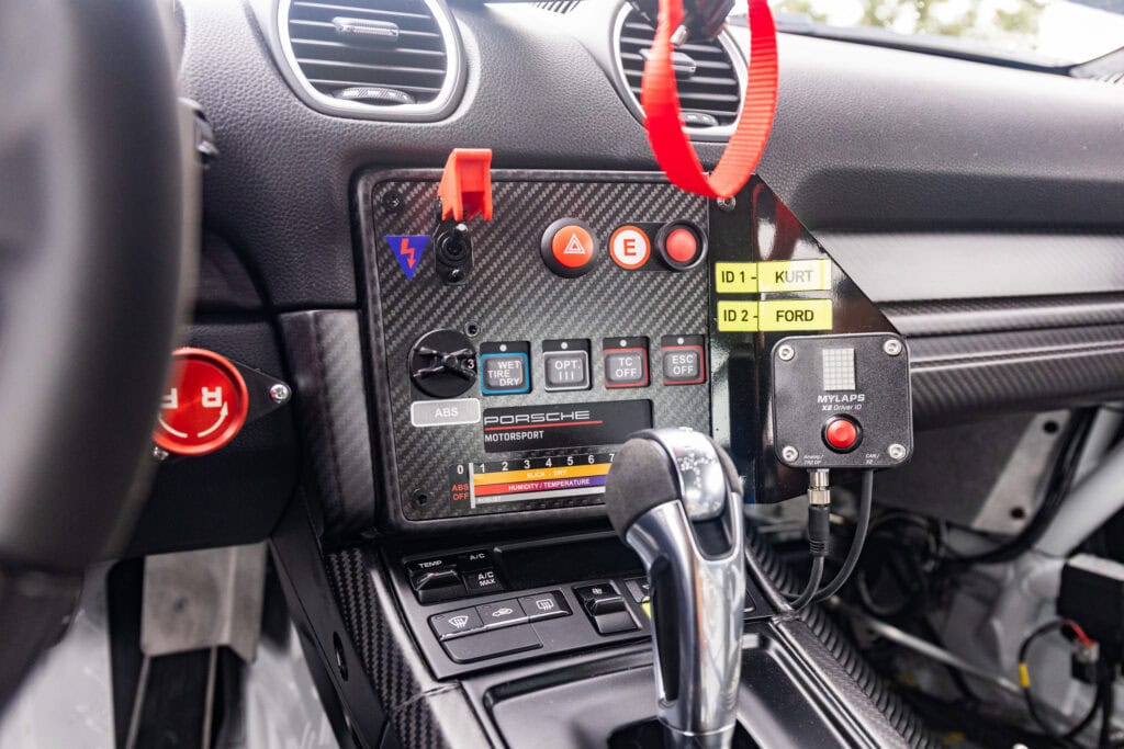 Close-up of race car dashboard with data logging and control devices.