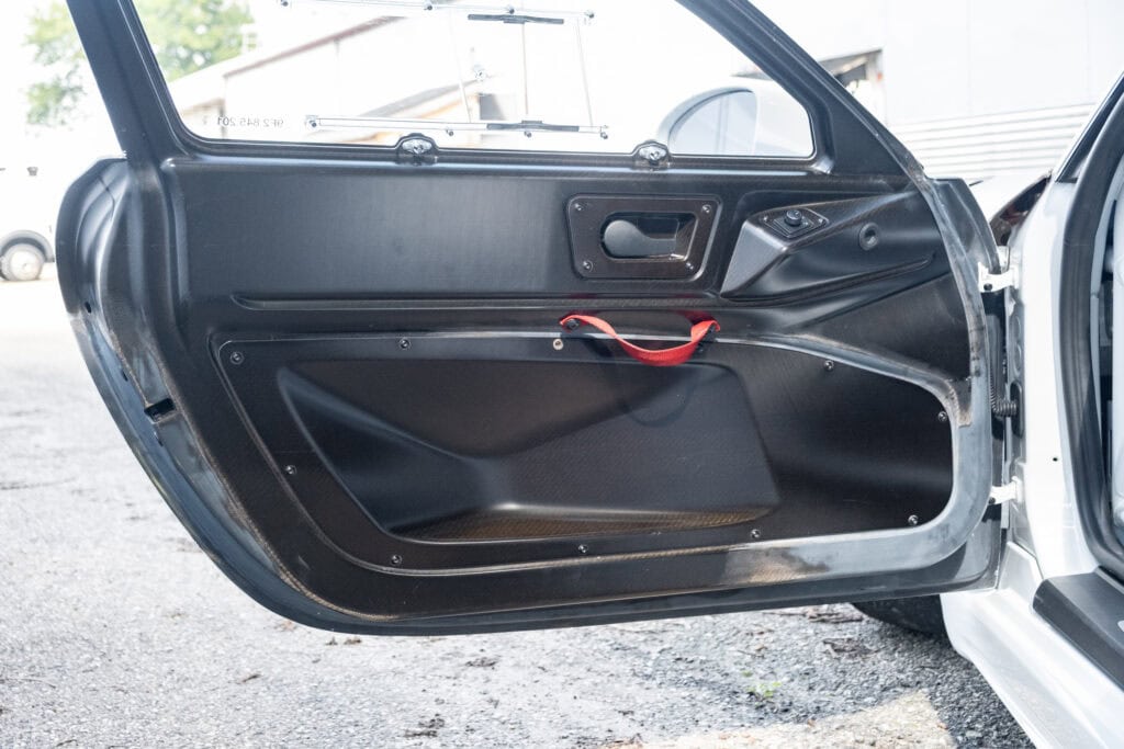 Close-up of a black car door interior with handle and window controls.