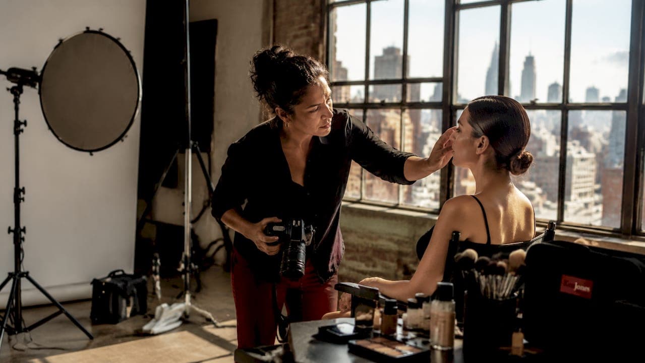 Photographer adjusting beauty shoot lighting with model
