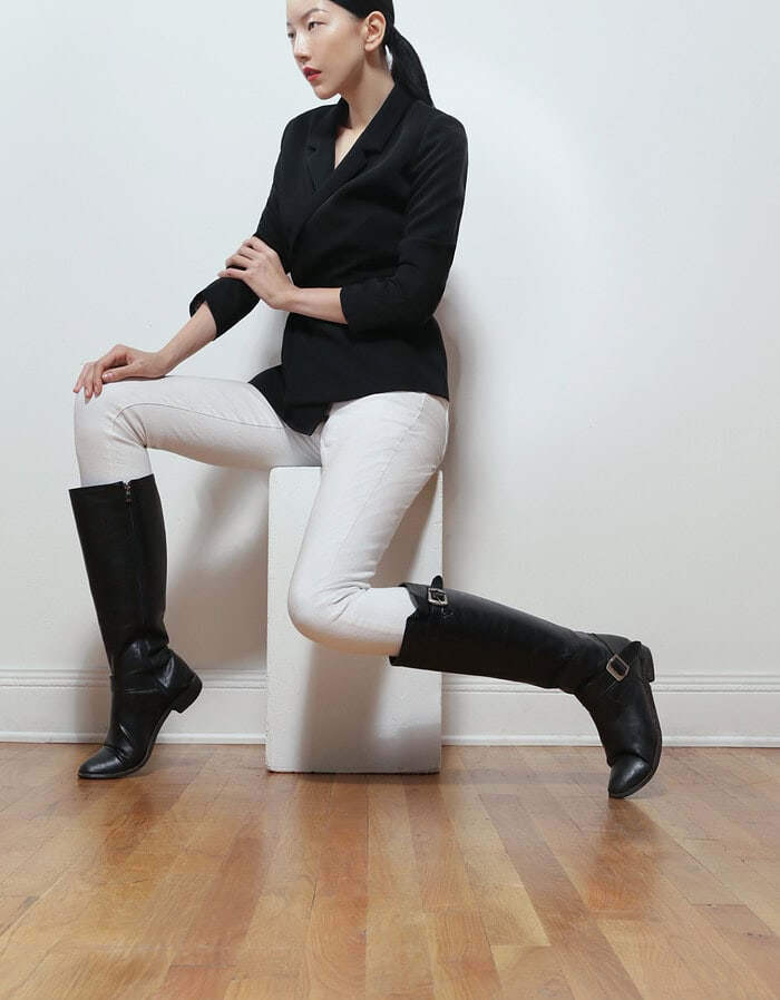 Fashion portrait of a woman in black blazer and white pants with black boots. photographer NYC