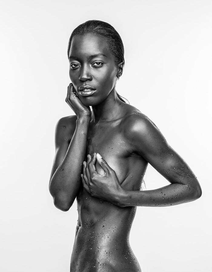 Black and white portrait of a topless woman with water droplets on her skin. photographer NYC