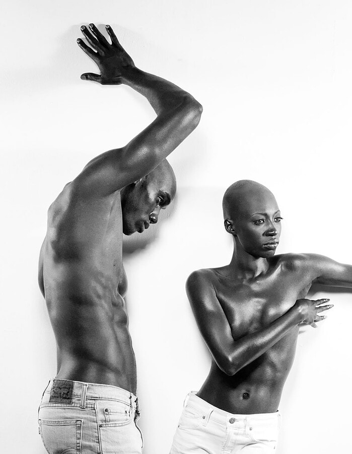 Two models creating angular poses with extended arms against a white studio background.