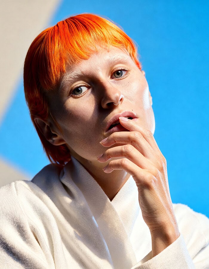 Portrait of a young woman with short orange hair and thoughtful expression. photographer NYC