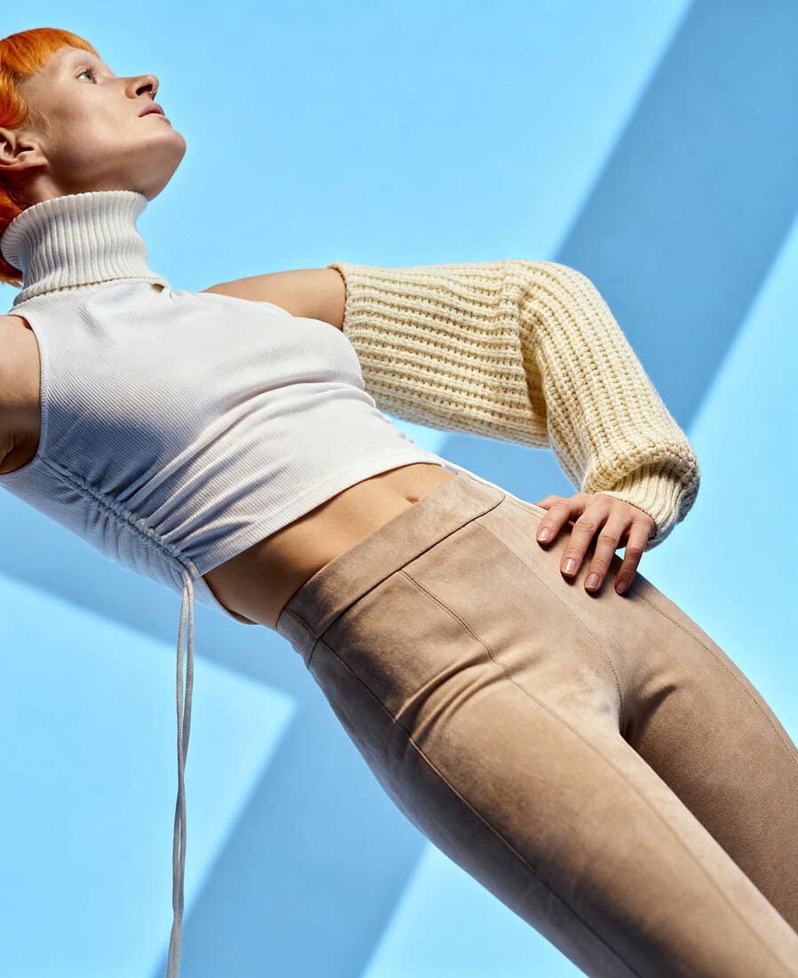 Fashion model with orange hair posing against blue geometric background. photographer NYC