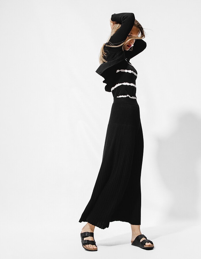 Fashion model in black and white striped sweater and black wide-leg pants posing. photographer NYC