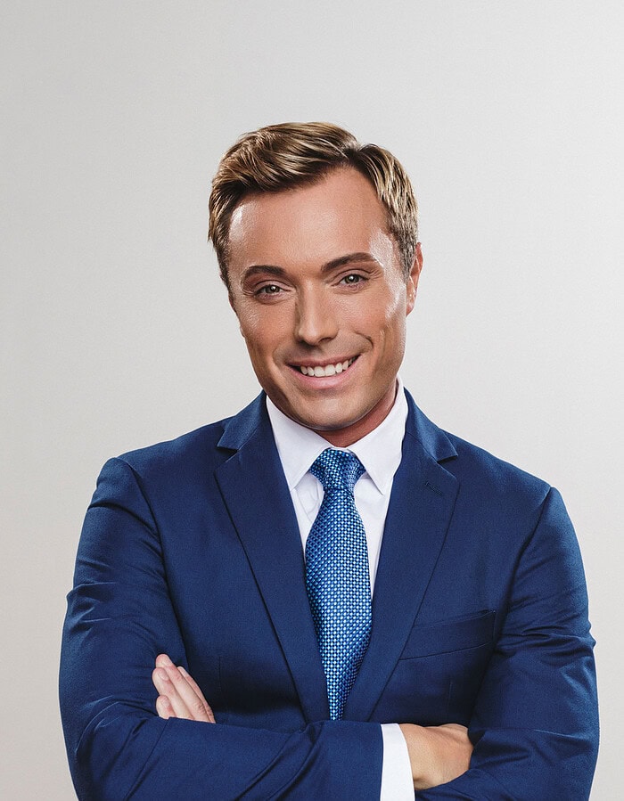Smiling male executive in a blue suit and patterned tie photographed in studio.