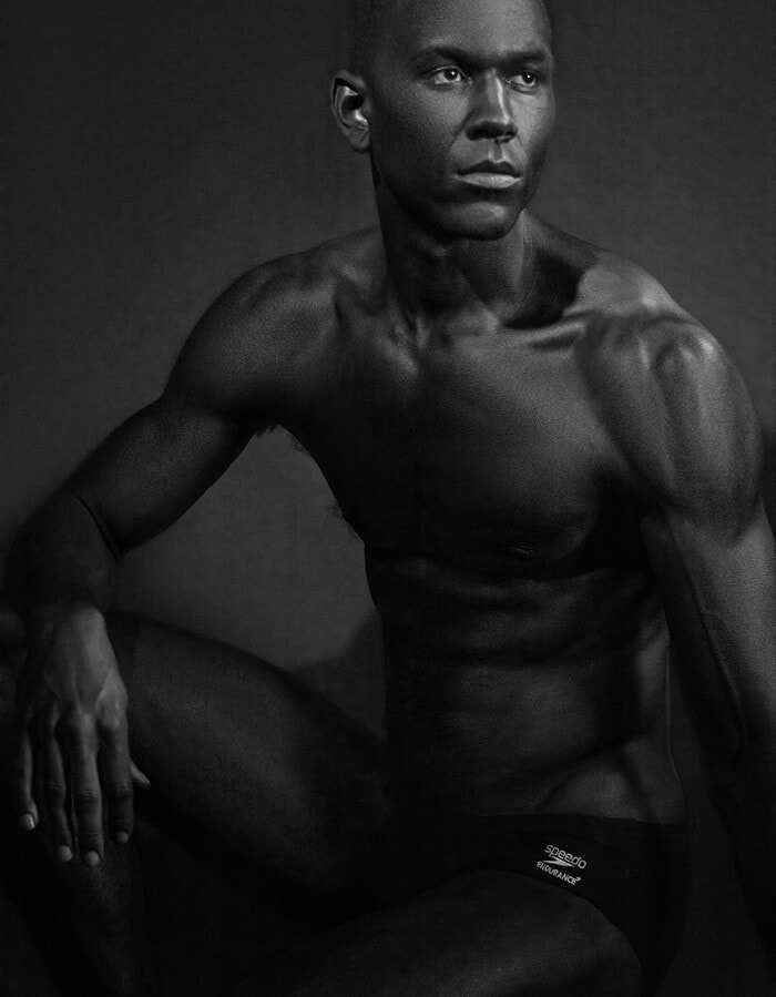 Seated male model looking away in a low-key black-and-white portrait