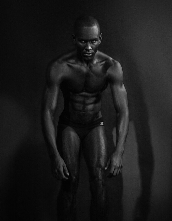 Full-length male model photographed with motion blur in a dark studio