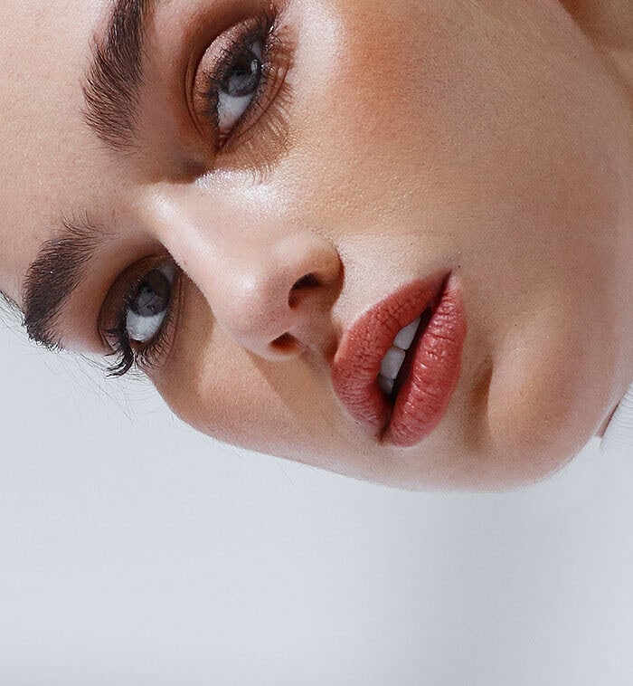 Close beauty portrait of a fashion model wearing a white turtleneck against a pale gray background.