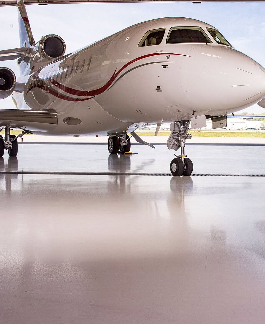 Executive standing in an aircraft hangar between two corporate jets.