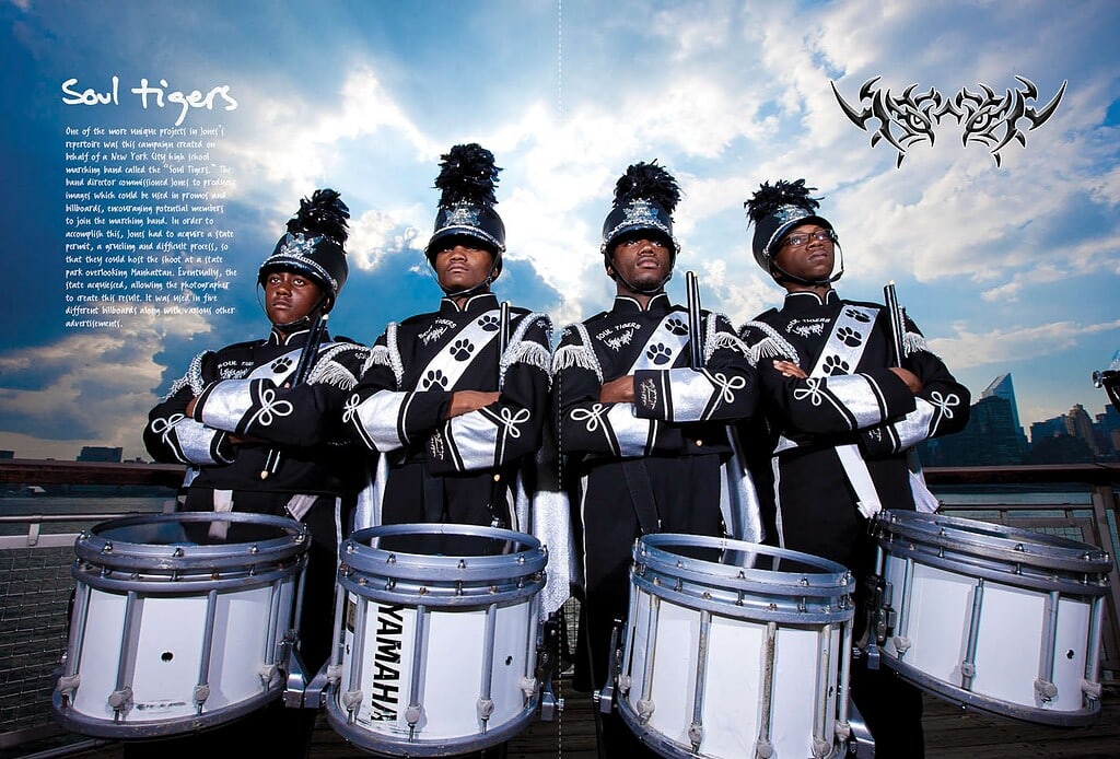 Four Soul Tigers marching band drummers posed with instruments against a dramatic city skyline.