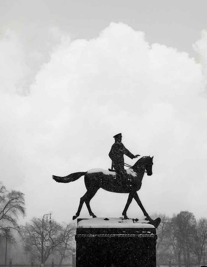 Black and white silhouette of an equestrian statue in falling snow in Moscow.