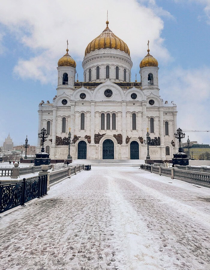 Cathedral of Christ the Savior in Moscow seen across a snowy plaza and bridge.