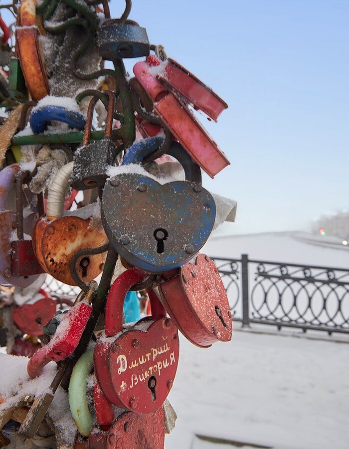 Close view of a snow-covered Moscow bronze monument beneath a bright winter sky.