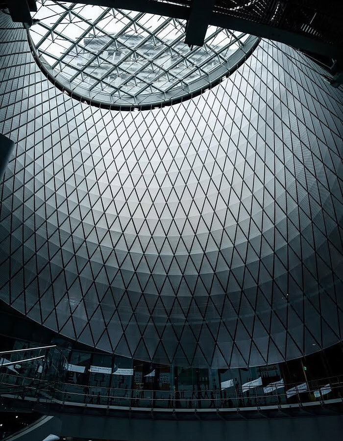 Geometric glass and steel interior of Fulton Center photographed during COVID in New York City.