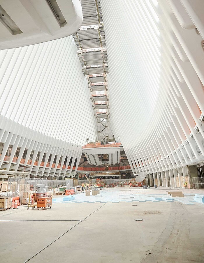 World Trade Center Oculus interior under construction with white ribs, scaffolding and unfinished floor.