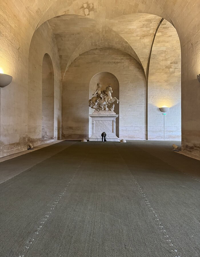 Equestrian statue inside a vaulted arched interior at the Palace of Versailles.