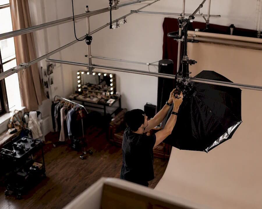 Production team adjusting lights in NYC photo studio
