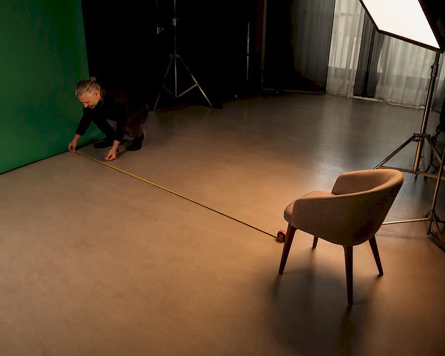 Videographer measuring green screen interview distance