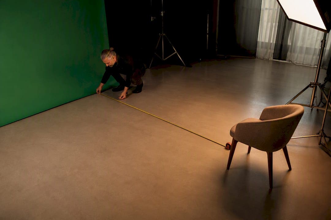 Videographer measuring green screen interview distance