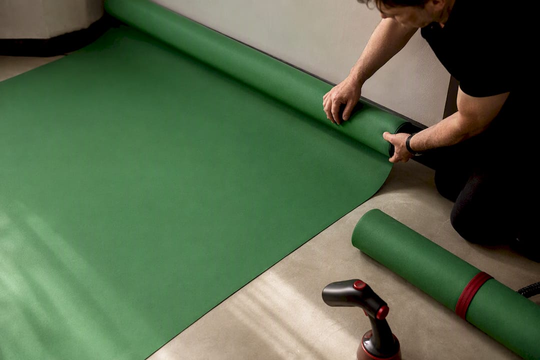 Green fabric backdrop extending across studio floor