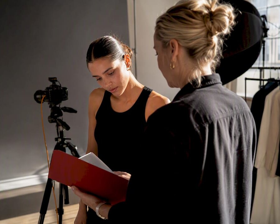 Model and producer reviewing release at fashion shoot