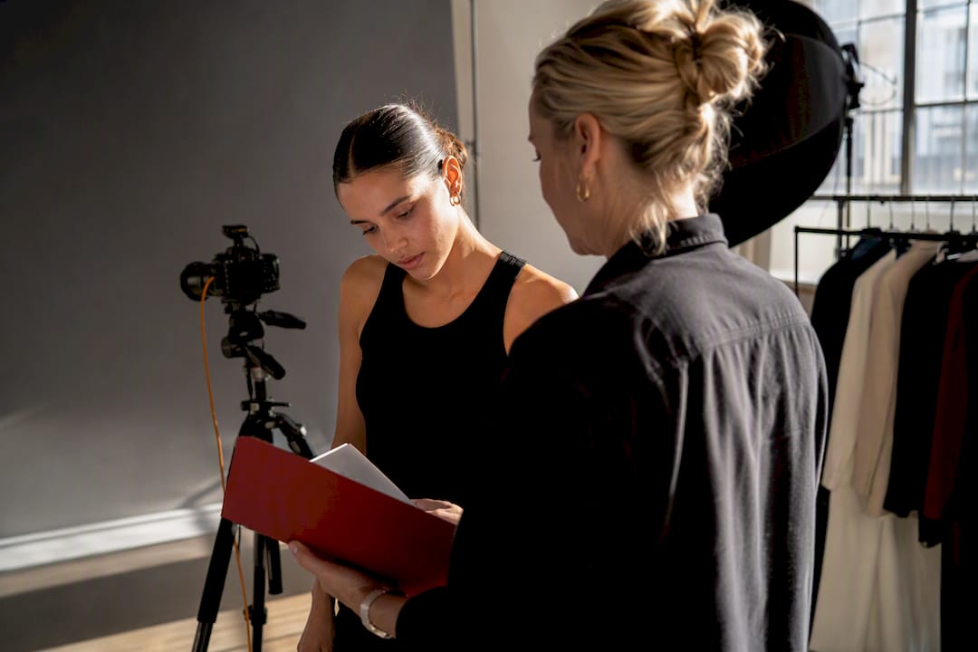 Model and producer reviewing release at fashion shoot