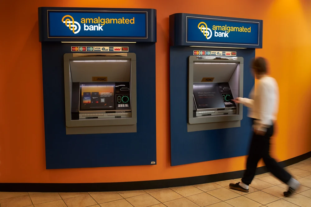 Amalgamated Bank ATM area photographed inside a branch with orange and blue brand colors