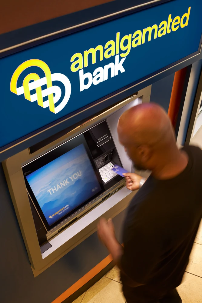 Customer using an Amalgamated Bank ATM in a branded branch environment
