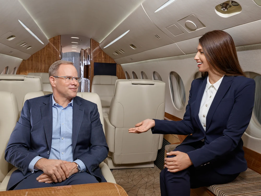 Two Dassault Falcon Jet executives in conversation inside a private aircraft