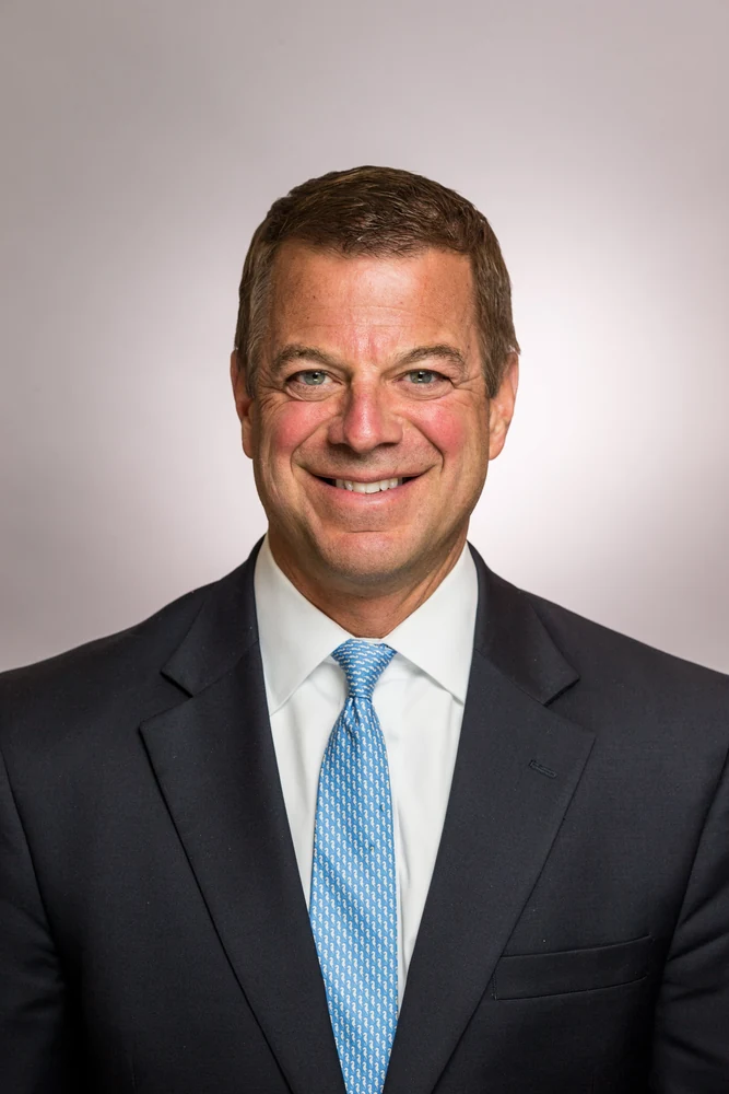 Corporate executive headshot in suit and light blue tie