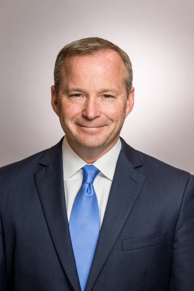 Corporate executive headshot in blue suit and tie