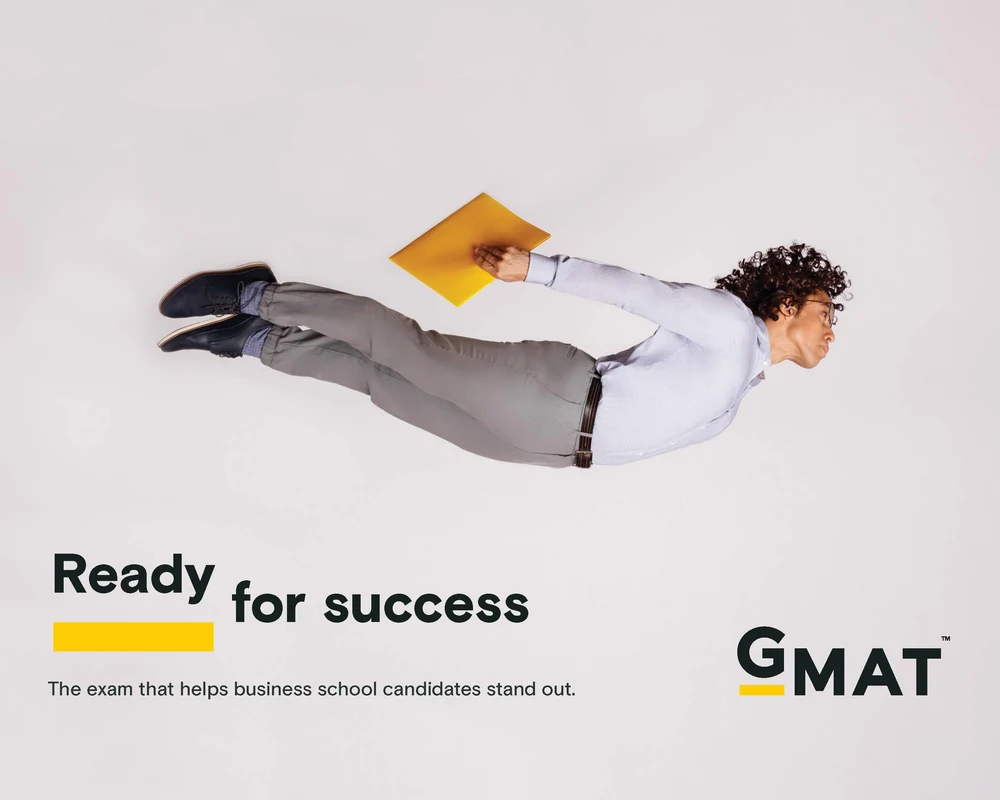 GMAT advertising campaign image of a business student appearing to fly with a folder