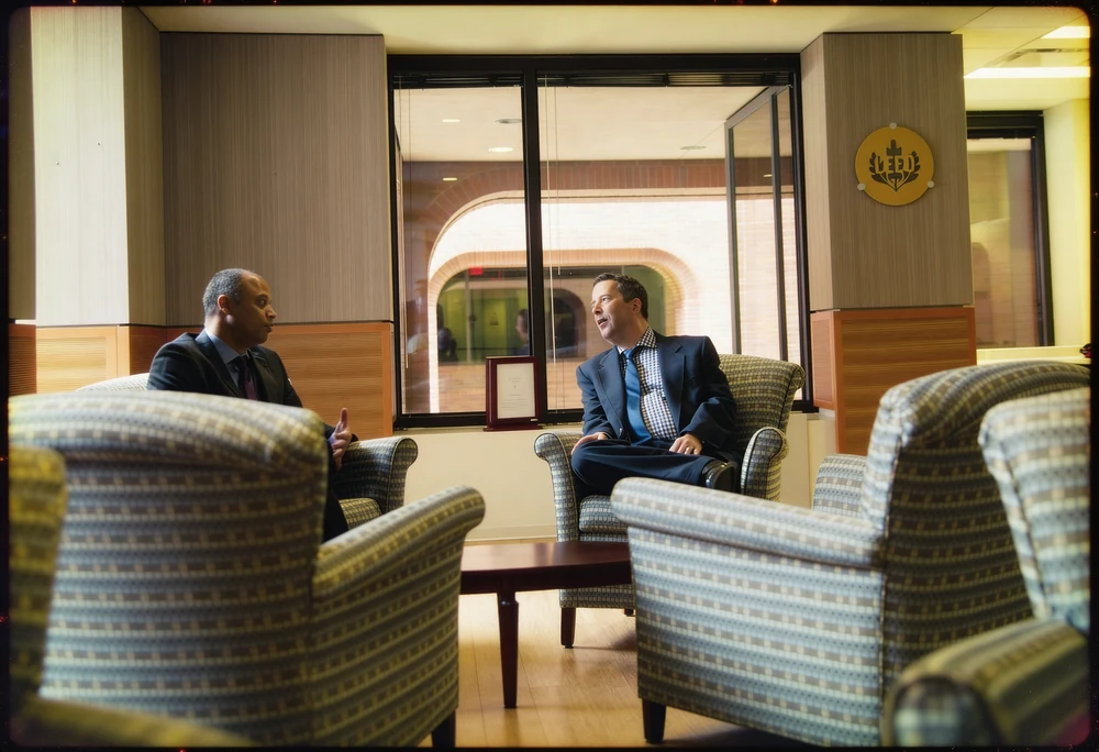Two executives in conversation seated in an institutional lobby